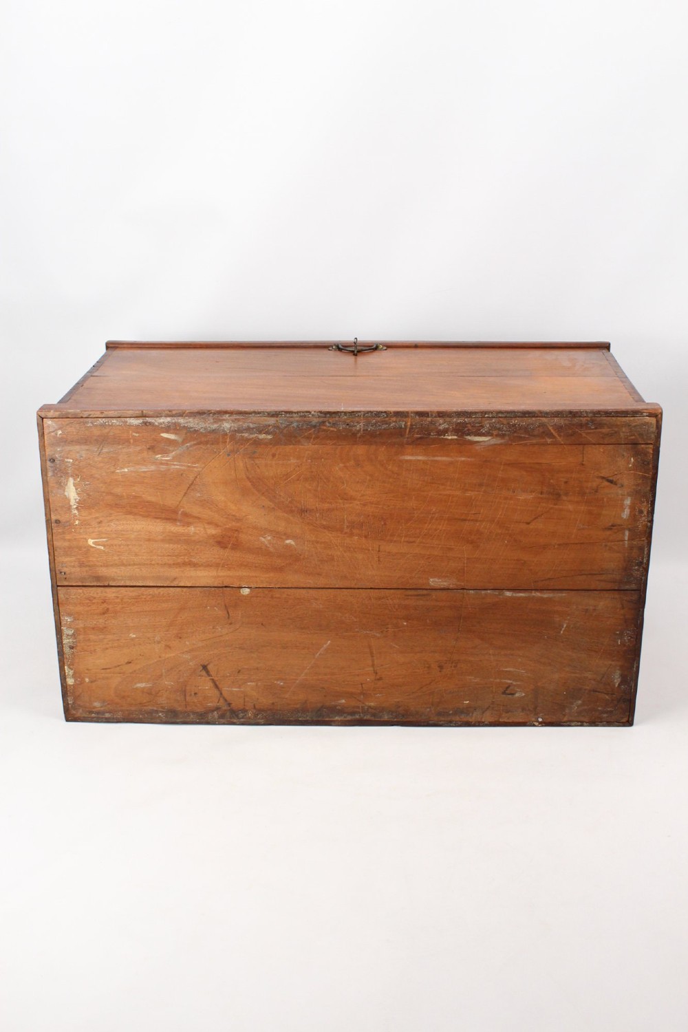 A rectangular Victorian mahogany storage chest featuring exposed dovetail corner joints, a flat hinged lid, and a central brass handle. View VI