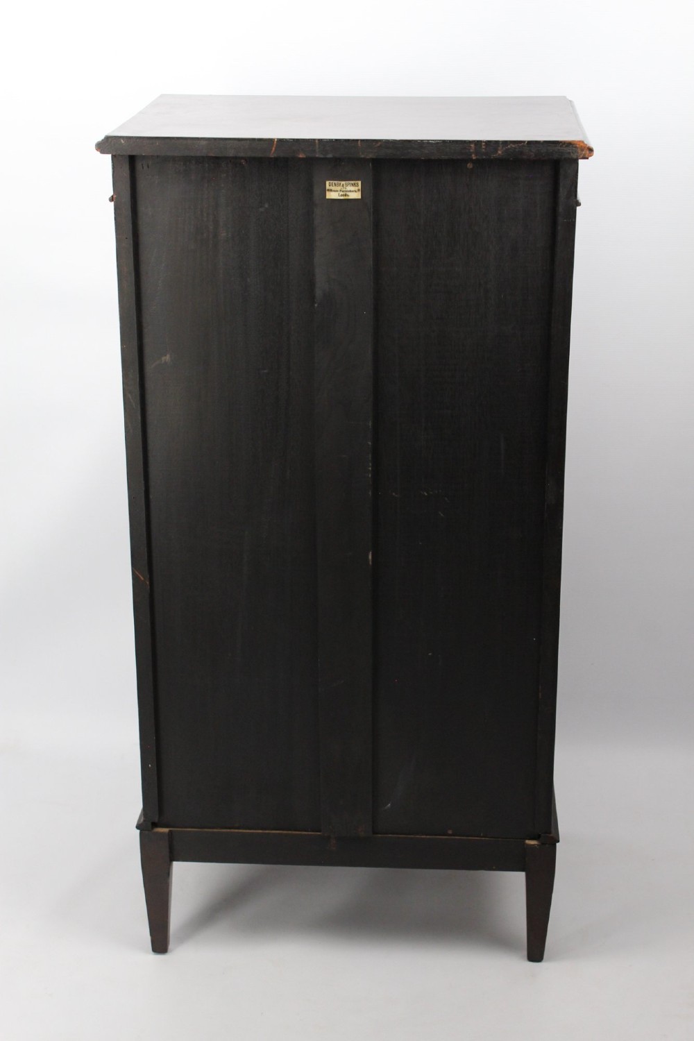An Edwardian dark mahogany pedestal cabinet featuring an oval flame mahogany panel, carved scroll frieze, and square tapered legs. View VI