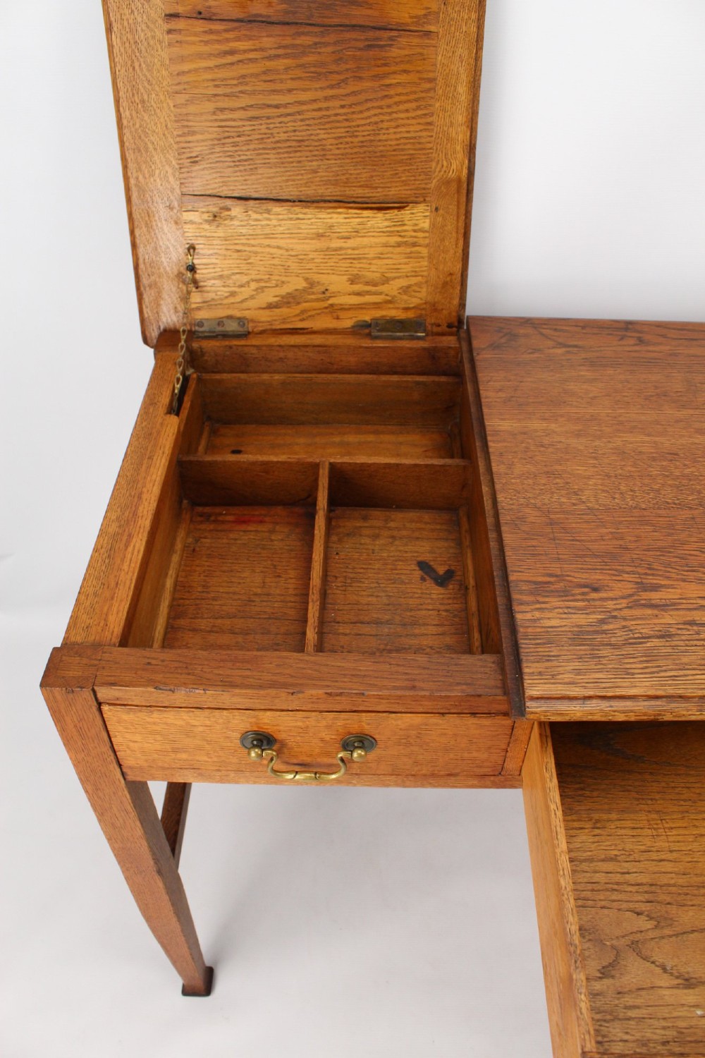 A late Victorian Arts and Crafts oak writing desk featuring drawers with brass swan-neck handles and tapered square legs. View VI