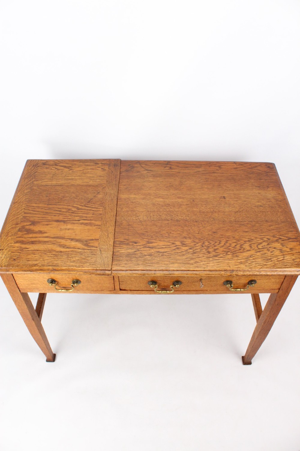 A late Victorian Arts and Crafts oak writing desk featuring drawers with brass swan-neck handles and tapered square legs. View VIII