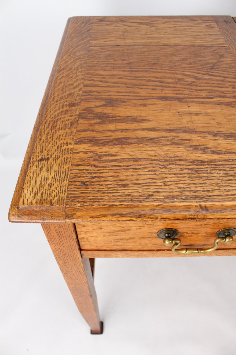 A late Victorian Arts and Crafts oak writing desk featuring drawers with brass swan-neck handles and tapered square legs. View IX