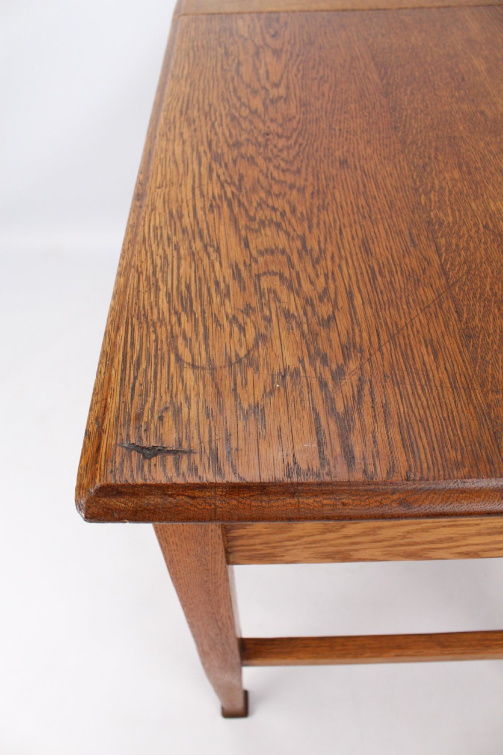 A late Victorian Arts and Crafts oak writing desk featuring drawers with brass swan-neck handles and tapered square legs. View X