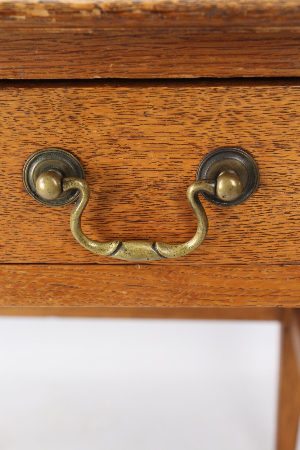 A late Victorian Arts and Crafts oak writing desk featuring drawers with brass swan-neck handles and tapered square legs. View XI