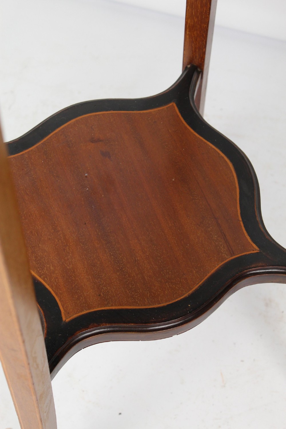 A tall Edwardian mahogany plant stand featuring shaped inlaid panels, four slender splayed legs, a lower shelf, and a dark metal liner. View VIII