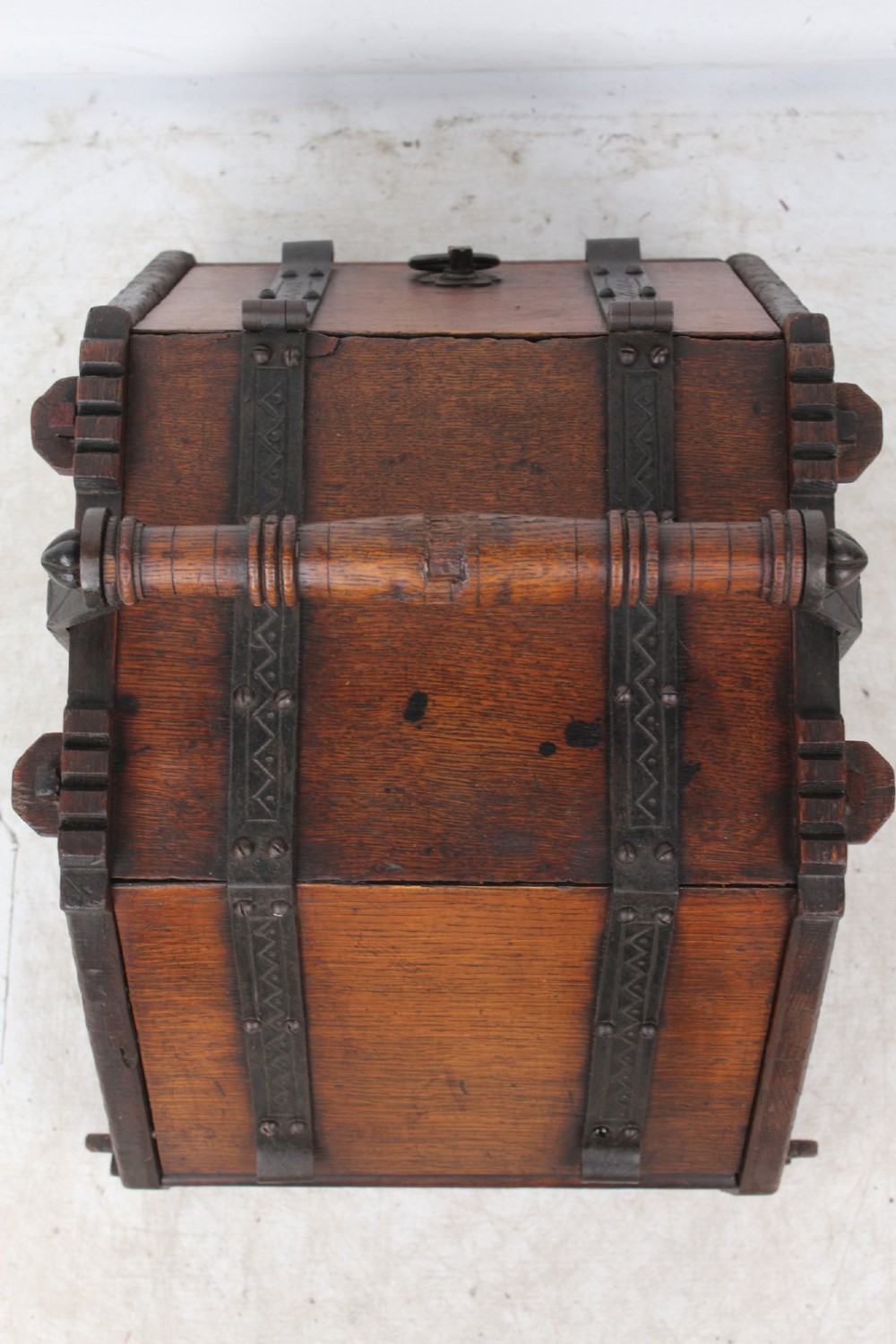 A Victorian Gothic Revival dark oak coal scuttle featuring sloped timber lids, a turned handle, and black wrought iron scrollwork straps. View VII