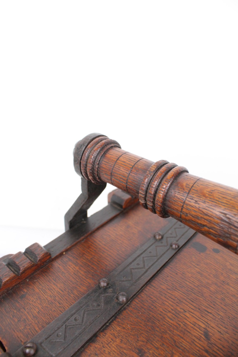 A Victorian Gothic Revival dark oak coal scuttle featuring sloped timber lids, a turned handle, and black wrought iron scrollwork straps. View XIII