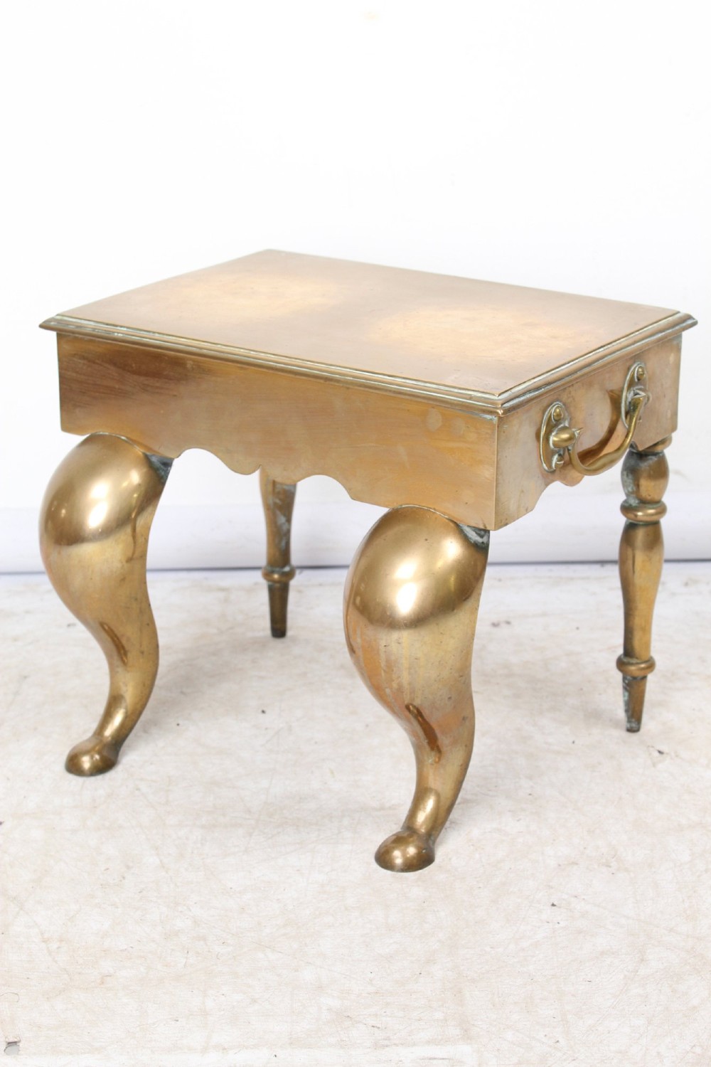 An antique Georgian brass footman featuring cabriole front legs, turned rear legs, side drop handles, and a rectangular top surface.