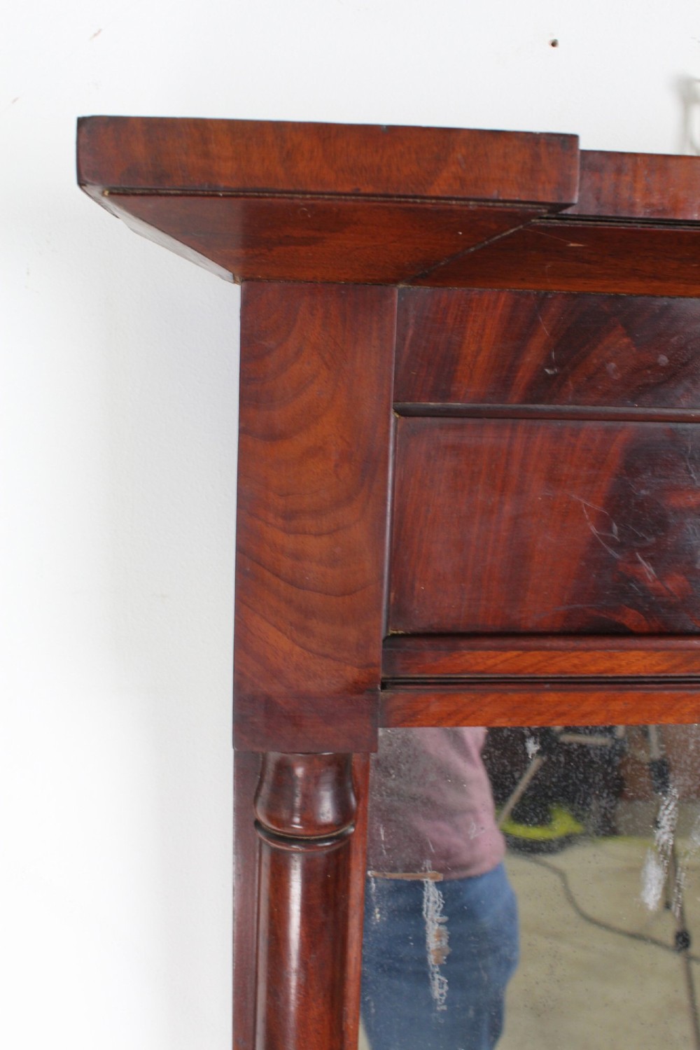 A small rectangular Regency mahogany pier mirror featuring an overhanging upper cornice, side column supports, and foxed glass. View VI