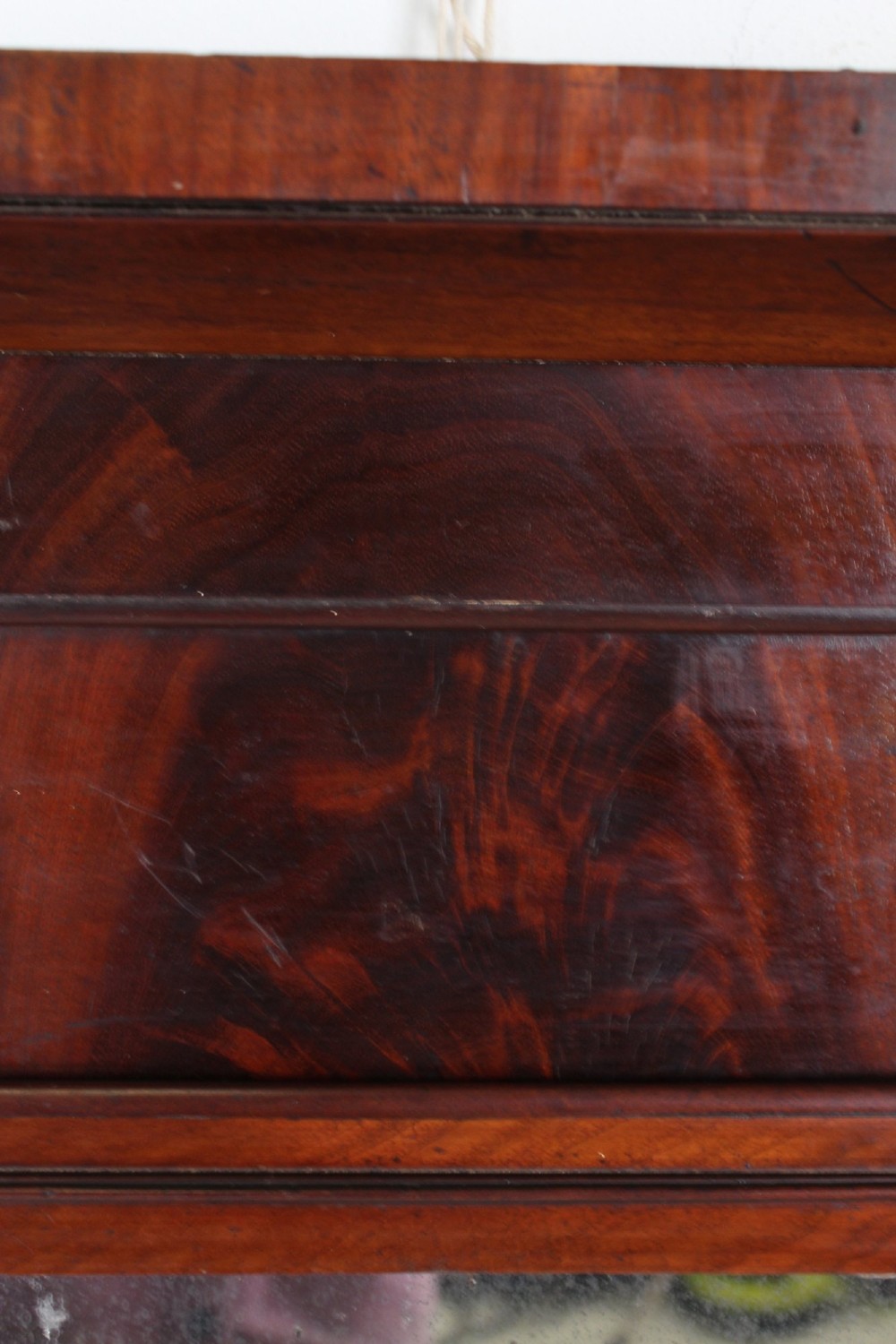 A small rectangular Regency mahogany pier mirror featuring an overhanging upper cornice, side column supports, and foxed glass. View VII