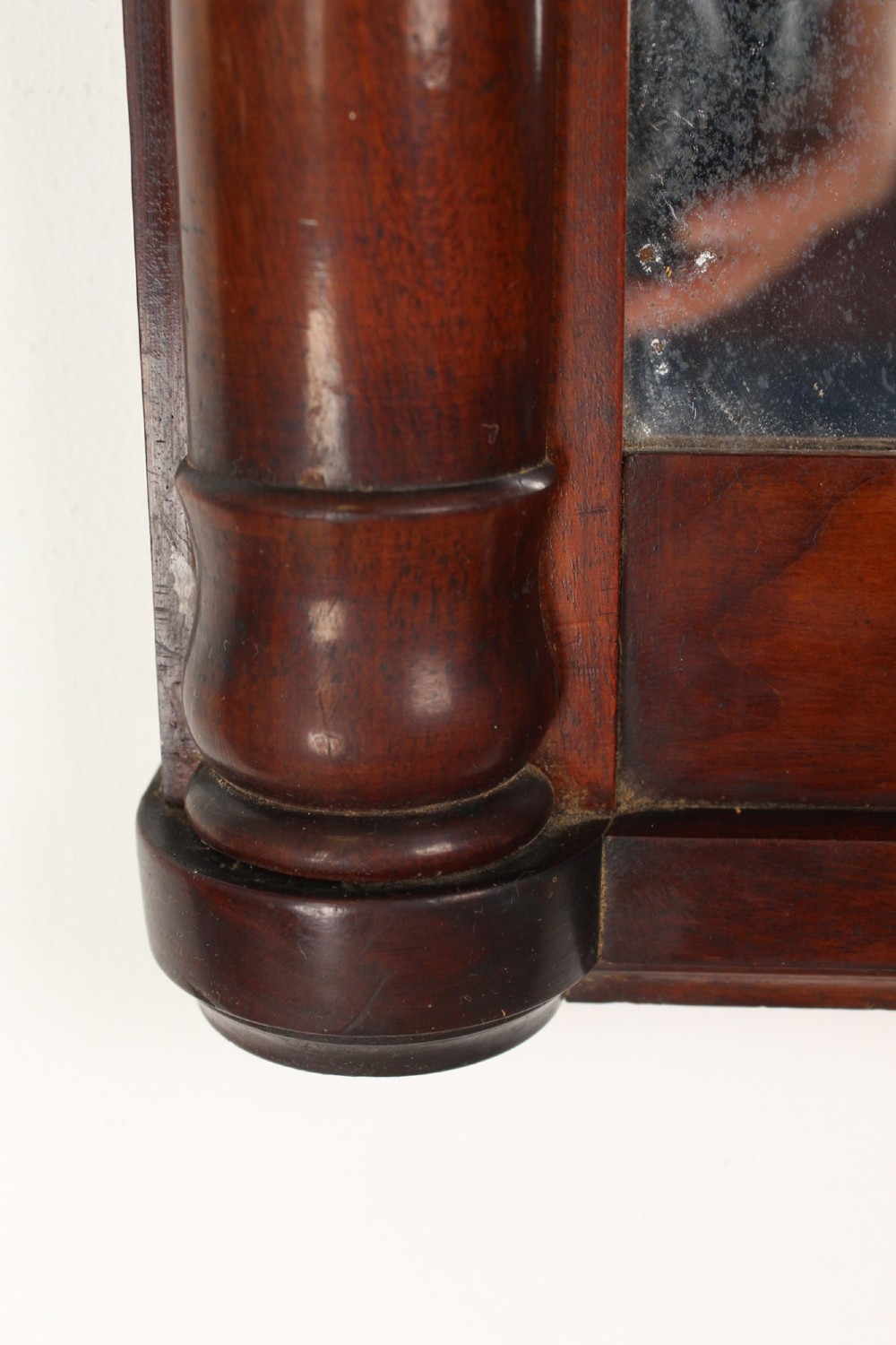 A small rectangular Regency mahogany pier mirror featuring an overhanging upper cornice, side column supports, and foxed glass. View VIII