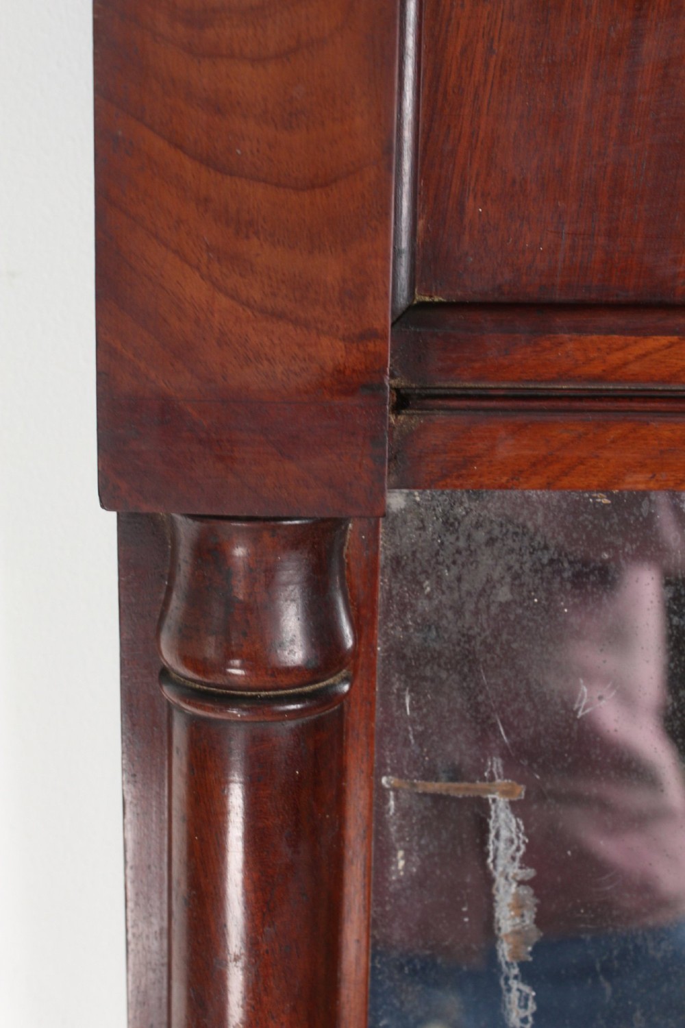 A small rectangular Regency mahogany pier mirror featuring an overhanging upper cornice, side column supports, and foxed glass. View XI