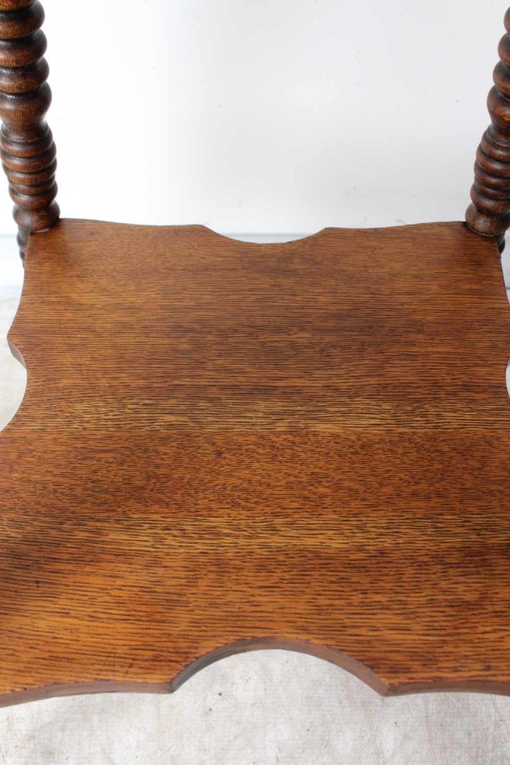 An antique warm brown oak side table featuring bobbin-turned legs, a lower rectangular shelf, and claw feet. View VI