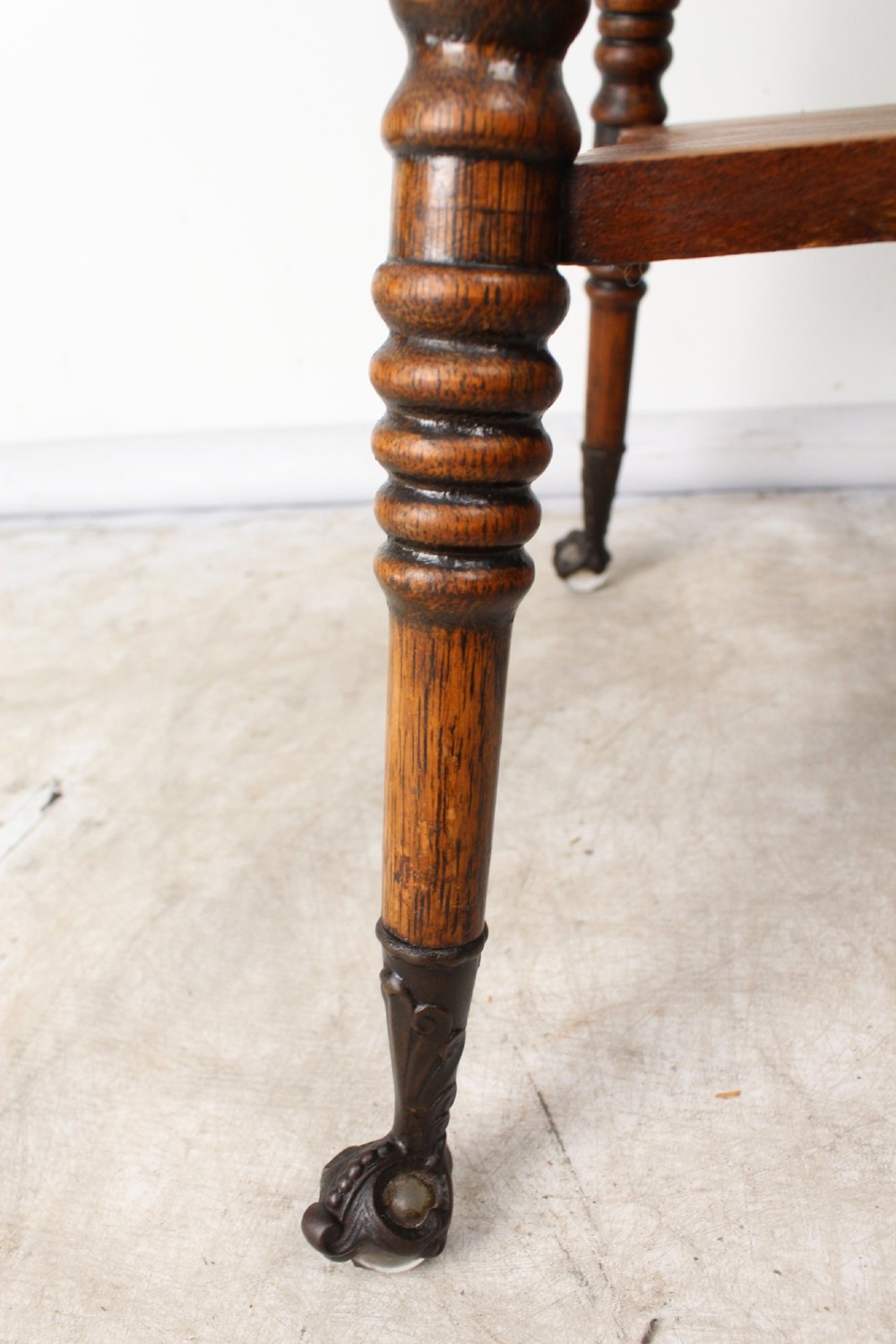 An antique warm brown oak side table featuring bobbin-turned legs, a lower rectangular shelf, and claw feet. View VIII