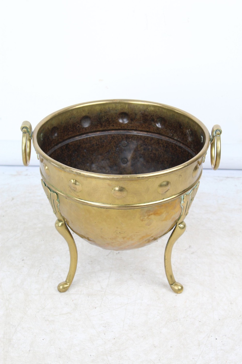 A Victorian Arts and Crafts brass log bin featuring raised round bosses around the rim, side drop rings, and curved legs. View IV