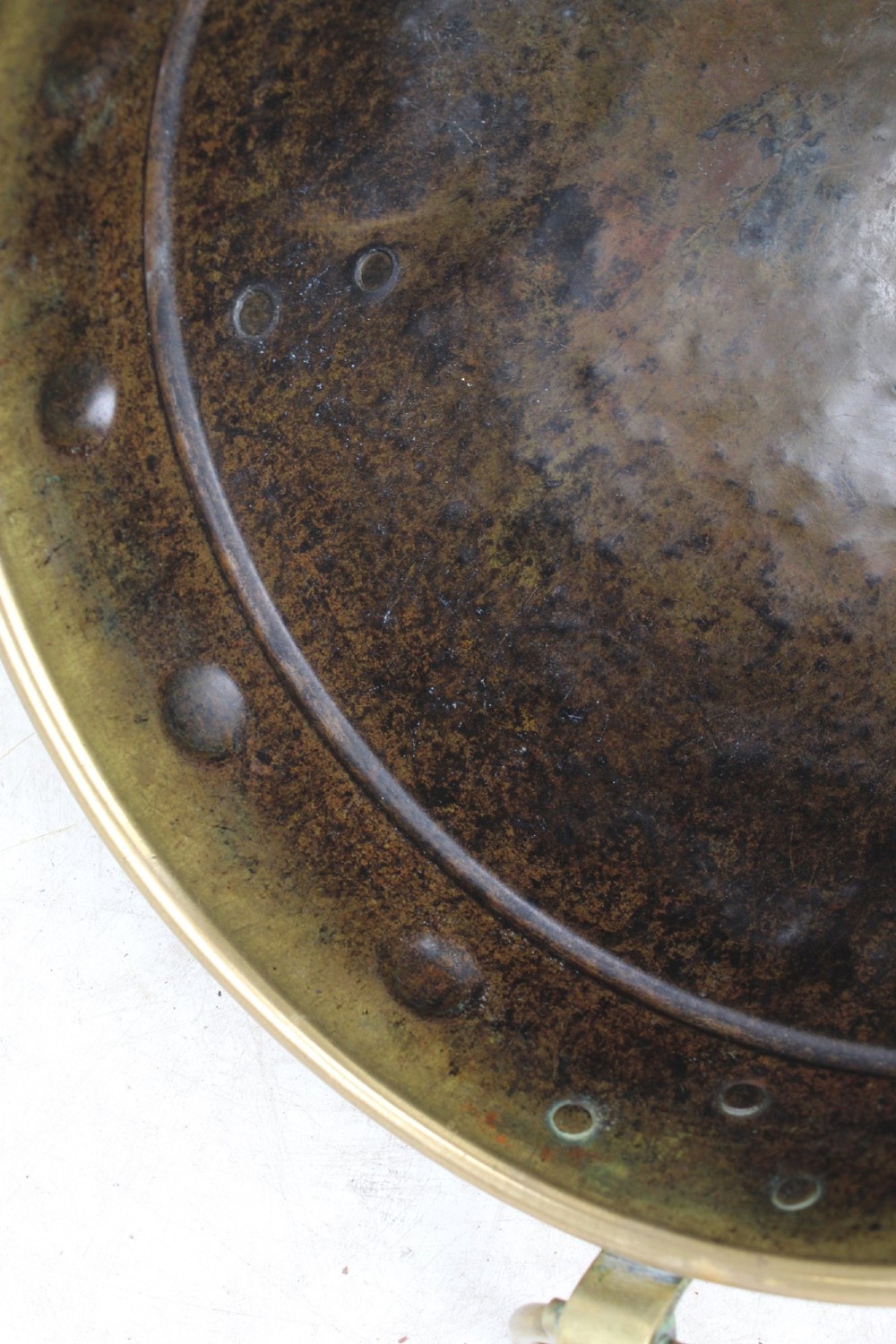 A Victorian Arts and Crafts brass log bin featuring raised round bosses around the rim, side drop rings, and curved legs. View VIII