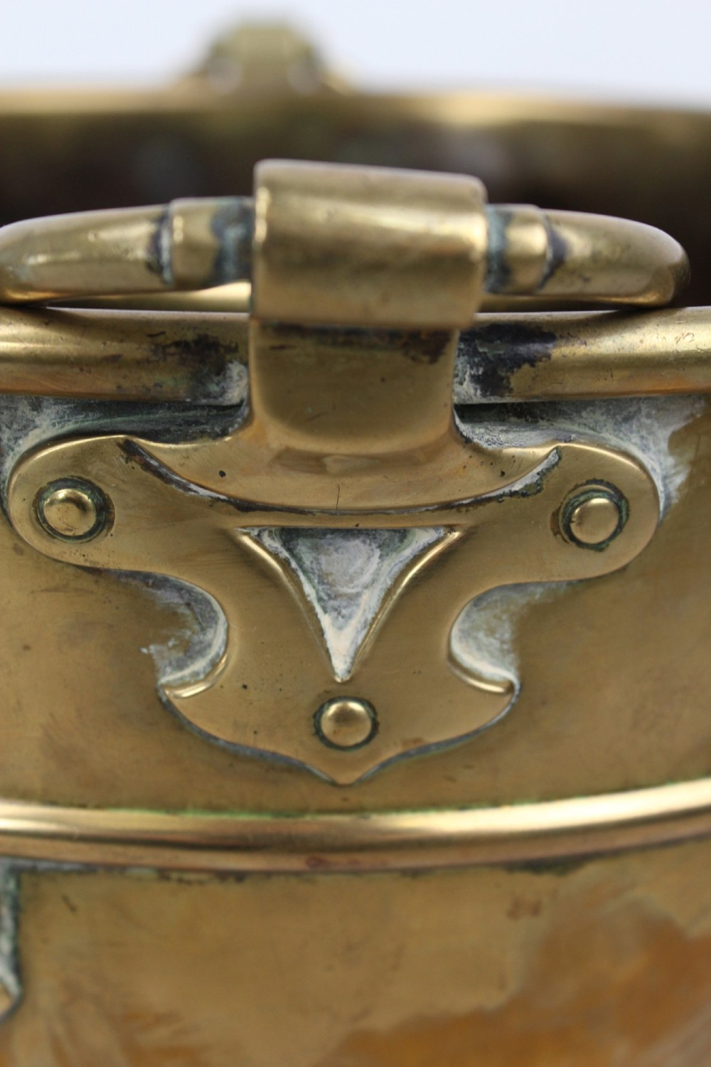 A Victorian Arts and Crafts brass log bin featuring raised round bosses around the rim, side drop rings, and curved legs. View IX