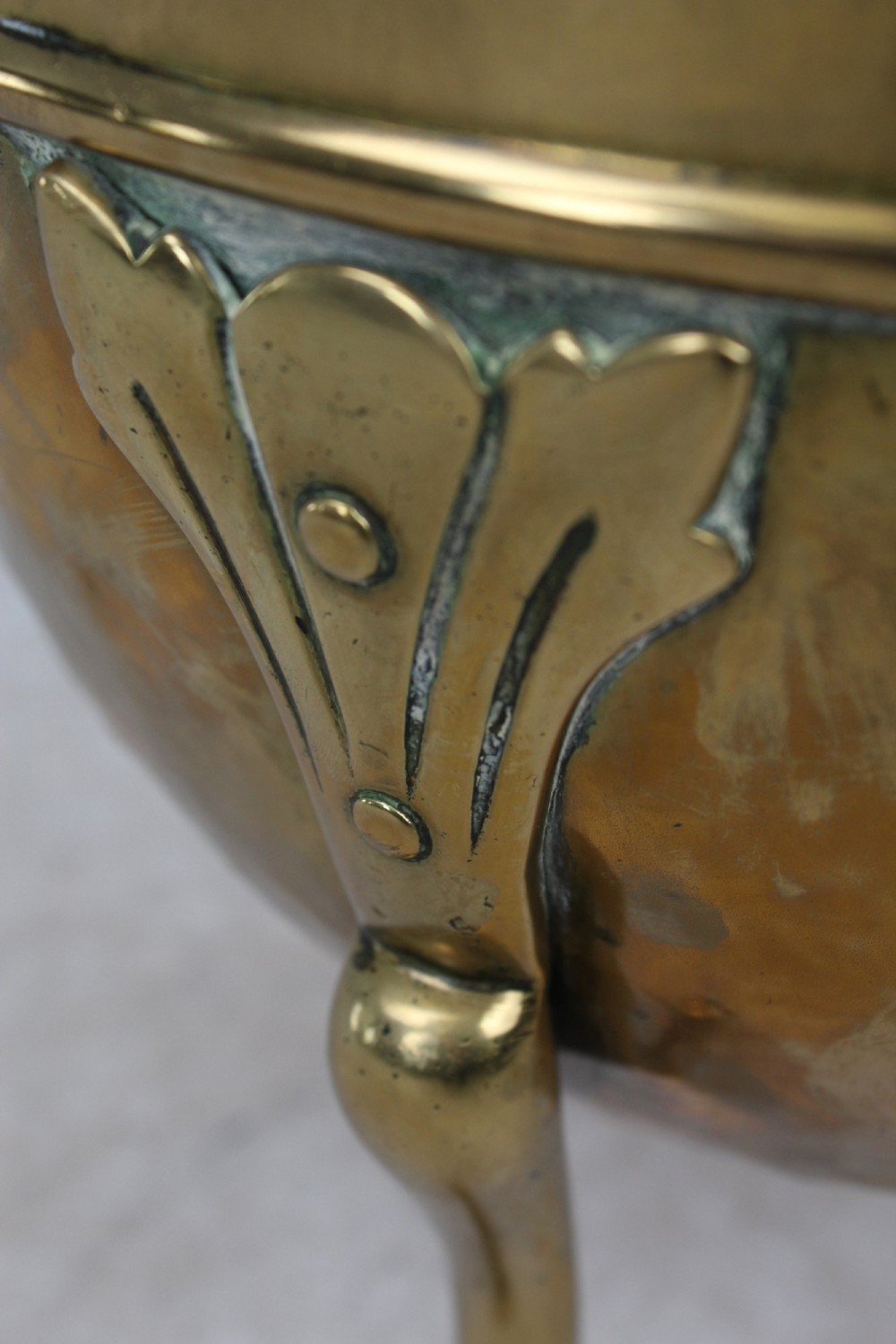 A Victorian Arts and Crafts brass log bin featuring raised round bosses around the rim, side drop rings, and curved legs. View X
