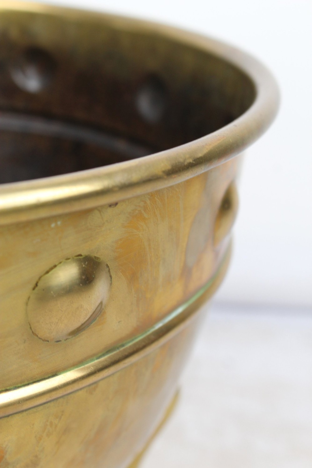 A Victorian Arts and Crafts brass log bin featuring raised round bosses around the rim, side drop rings, and curved legs. View XI