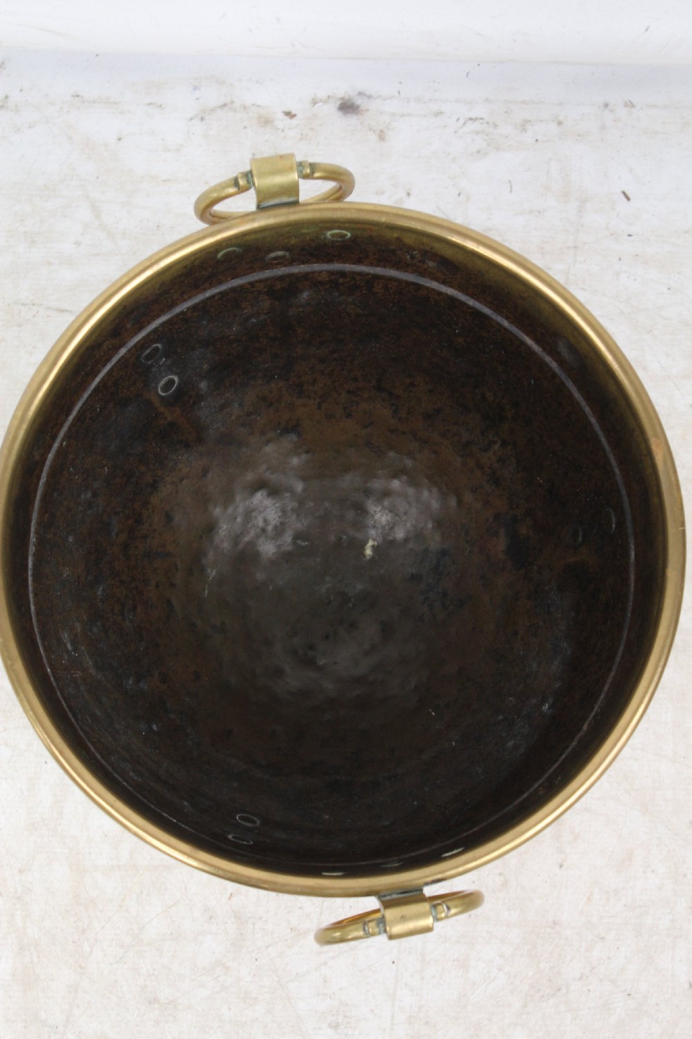A Victorian Arts and Crafts brass log bin featuring raised round bosses around the rim, side drop rings, and curved legs. View XIII