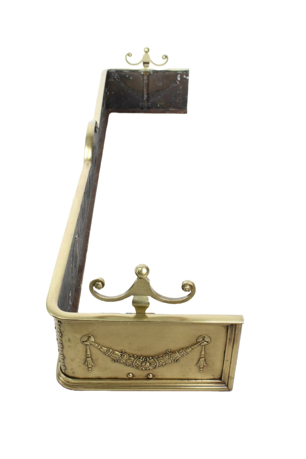 A long Victorian brass fireplace fender featuring embossed Neoclassical relief decoration of central urns, winged sphinxes, and foliate scrolls. View III