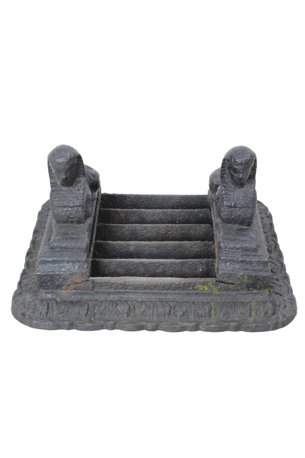 A dark cast iron boot scraper featuring twin sphinx figures flanking a central slatted grate set upon a decorative moulded base.