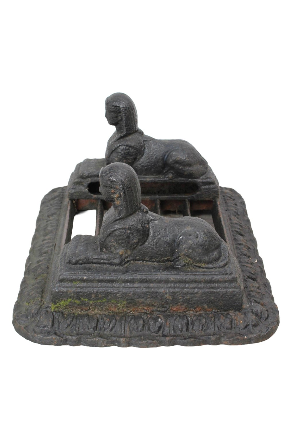 A dark cast iron boot scraper featuring twin sphinx figures flanking a central slatted grate set upon a decorative moulded base. View III
