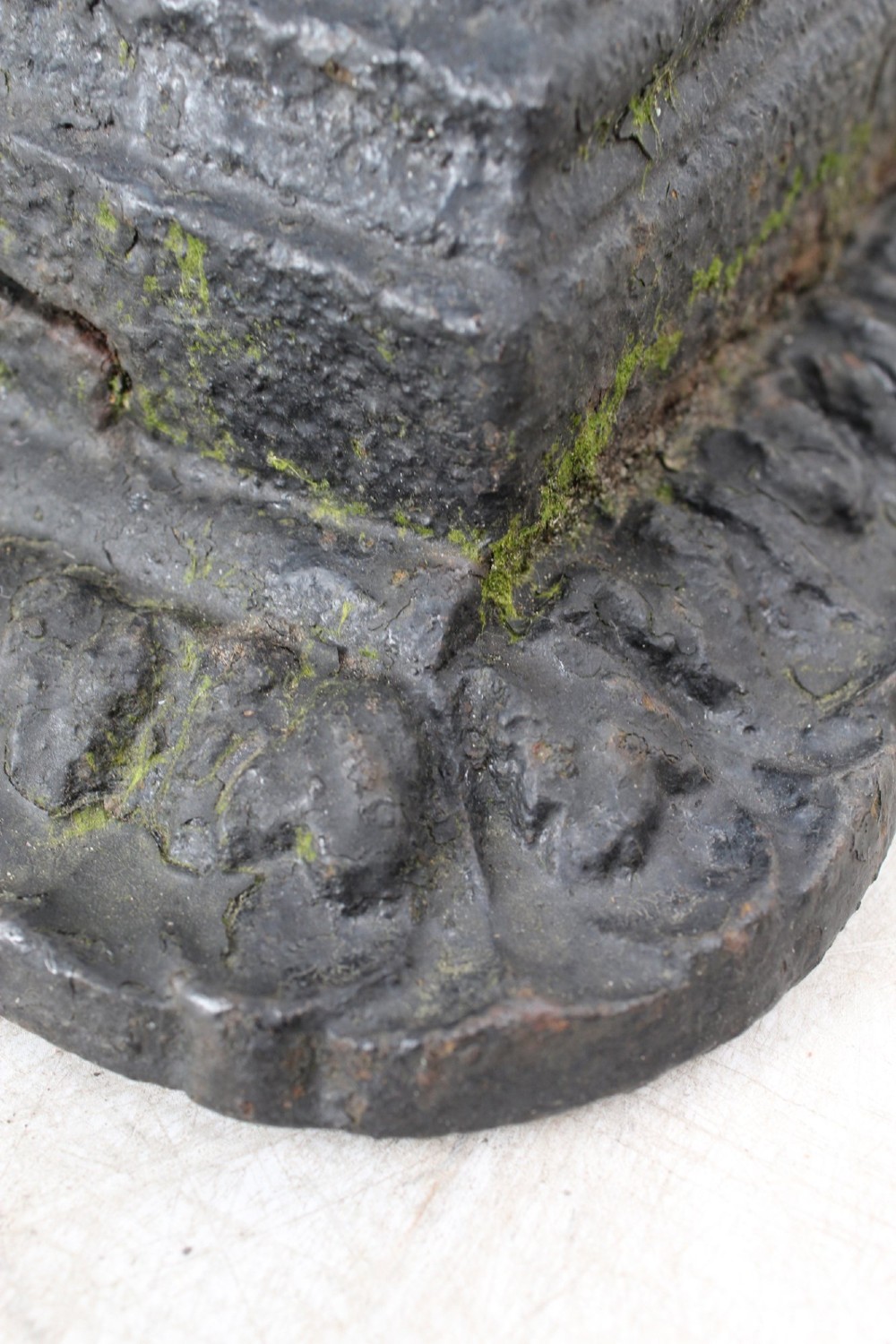 A dark cast iron boot scraper featuring twin sphinx figures flanking a central slatted grate set upon a decorative moulded base. View IX
