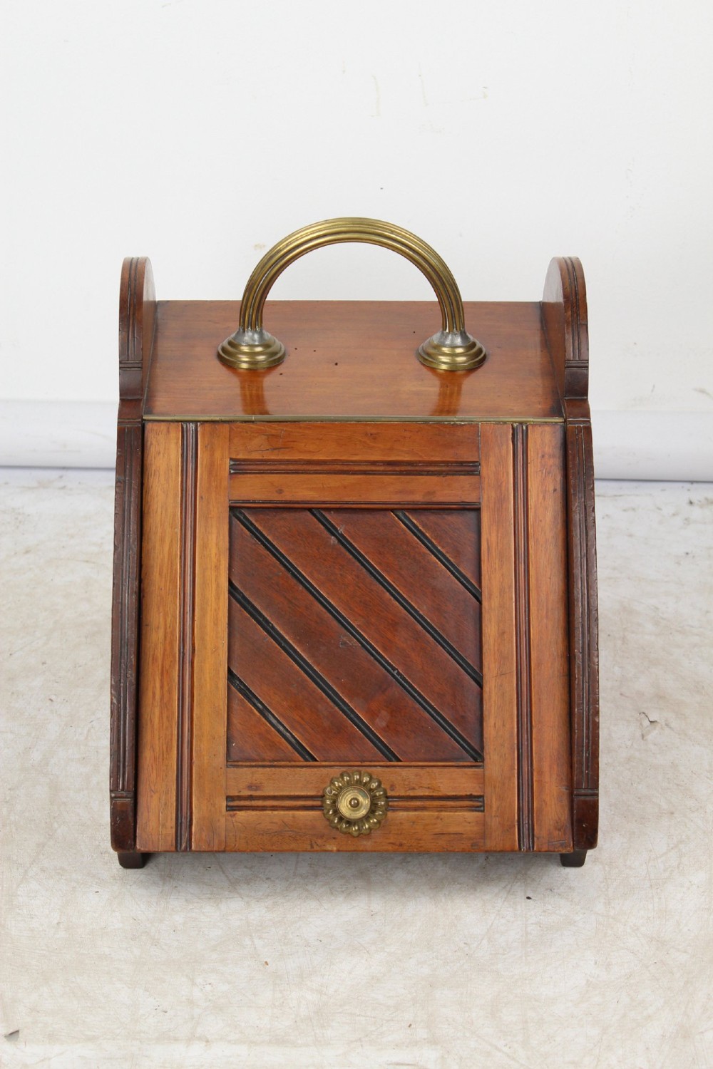 A Victorian mahogany coal scuttle featuring a slanted drop-front door with decorative timber inlay and a polished brass carrying handle on top. View IV