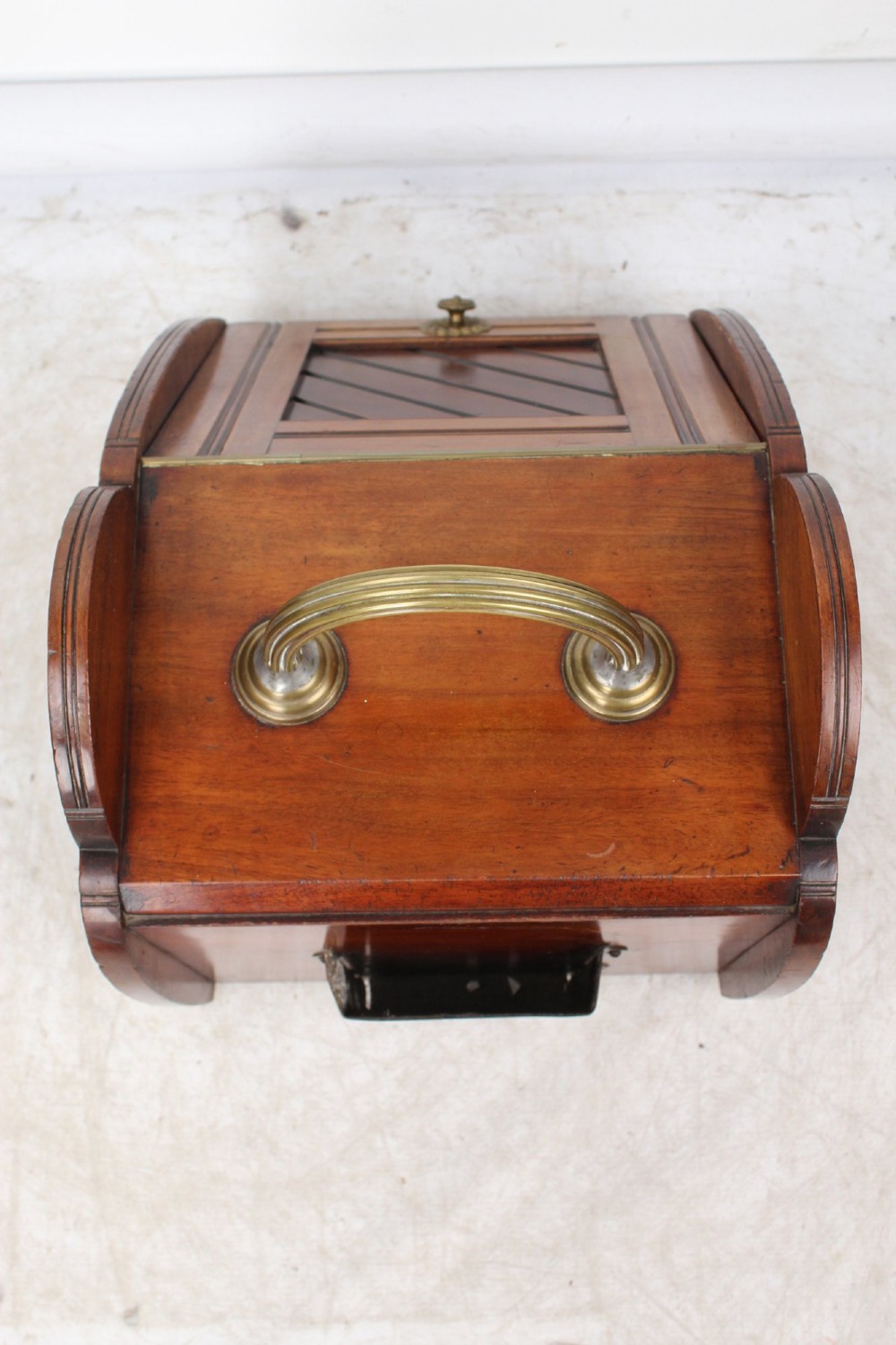 A Victorian mahogany coal scuttle featuring a slanted drop-front door with decorative timber inlay and a polished brass carrying handle on top. View VII