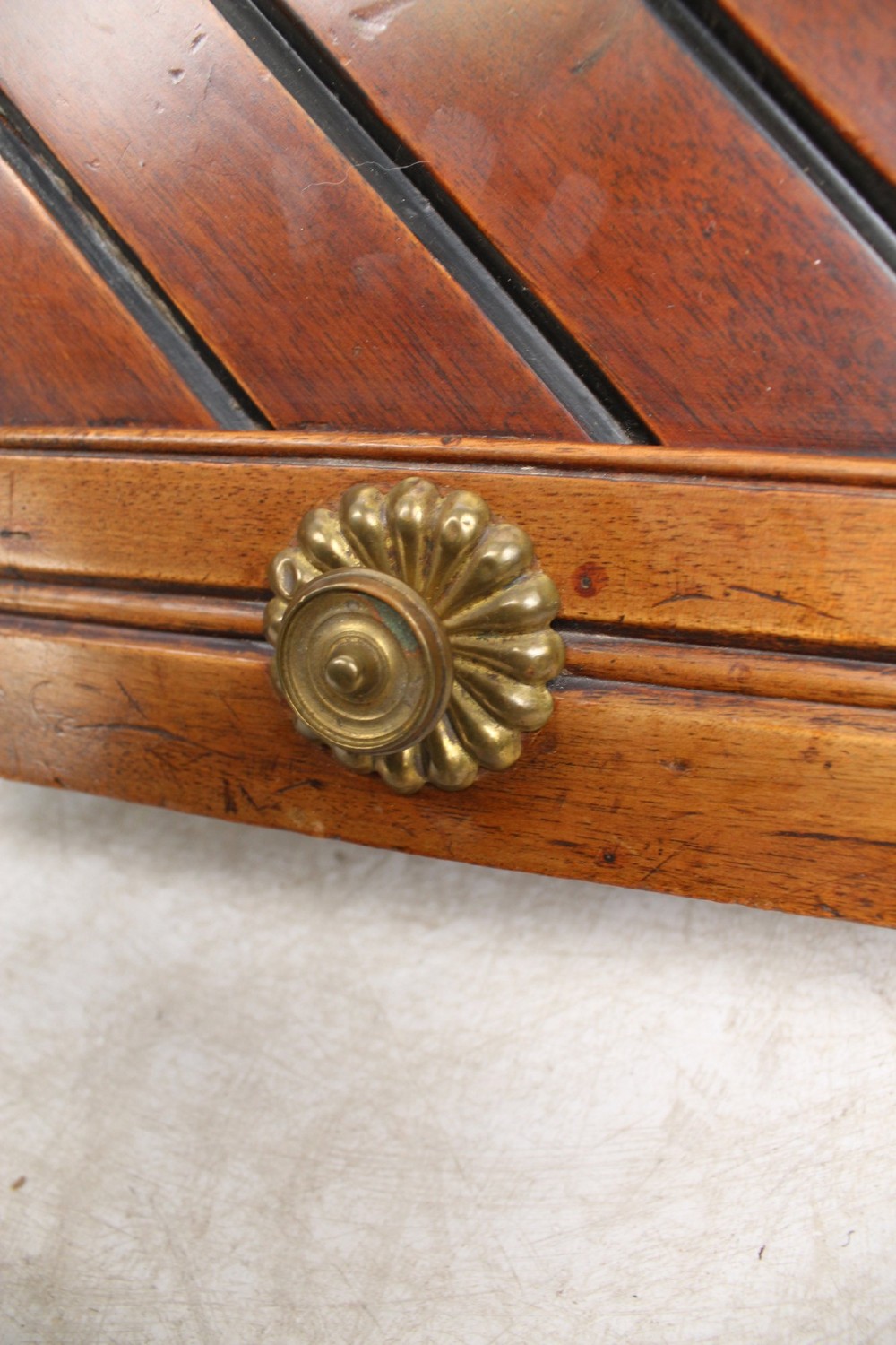 A Victorian mahogany coal scuttle featuring a slanted drop-front door with decorative timber inlay and a polished brass carrying handle on top. View X