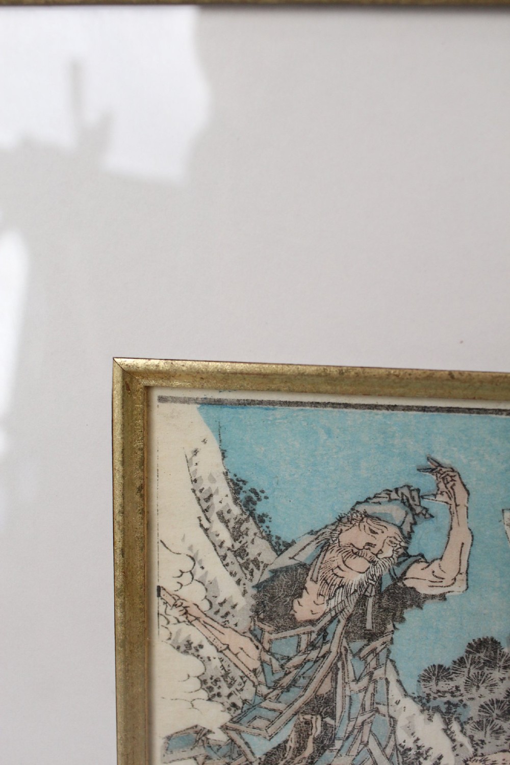 A pair of framed Japanese woodblock prints featuring detailed figurative and landscape illustrations mounted in cream mats within dark wooden frames. View XII