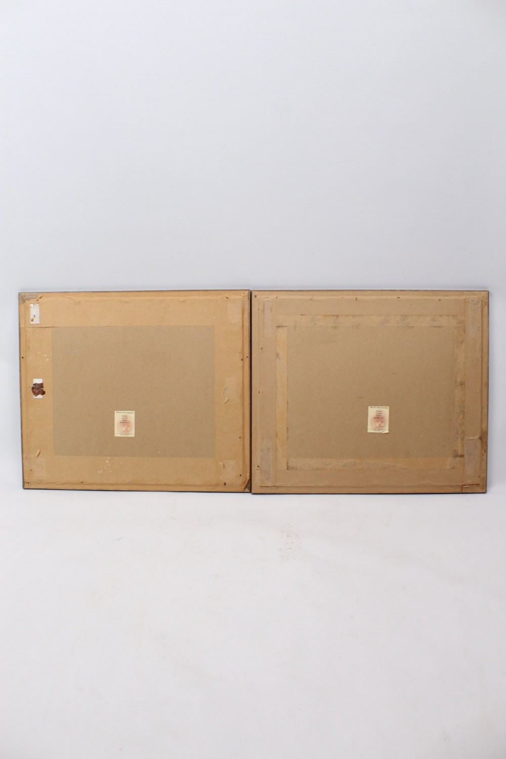 A pair of framed Japanese woodblock prints featuring detailed figurative and landscape illustrations mounted in cream mats within dark wooden frames. View XIII