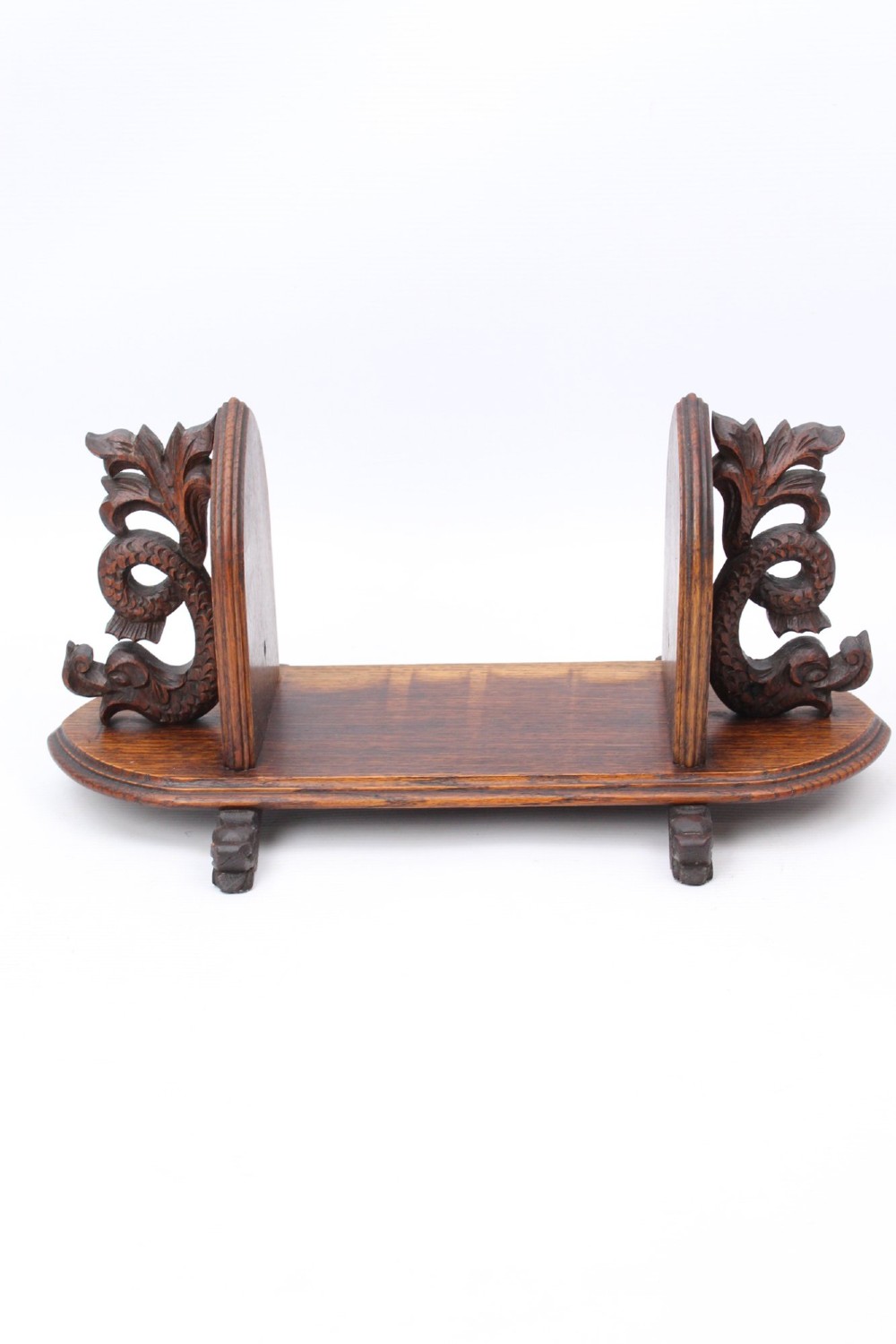 A dark oak desktop book stand featuring pointed arch uprights, carved mythical creature side accents, and scroll feet. View II