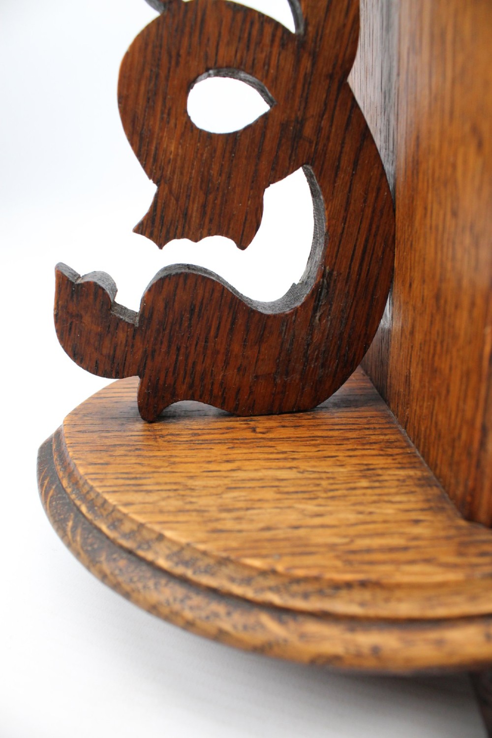 A dark oak desktop book stand featuring pointed arch uprights, carved mythical creature side accents, and scroll feet. View XII