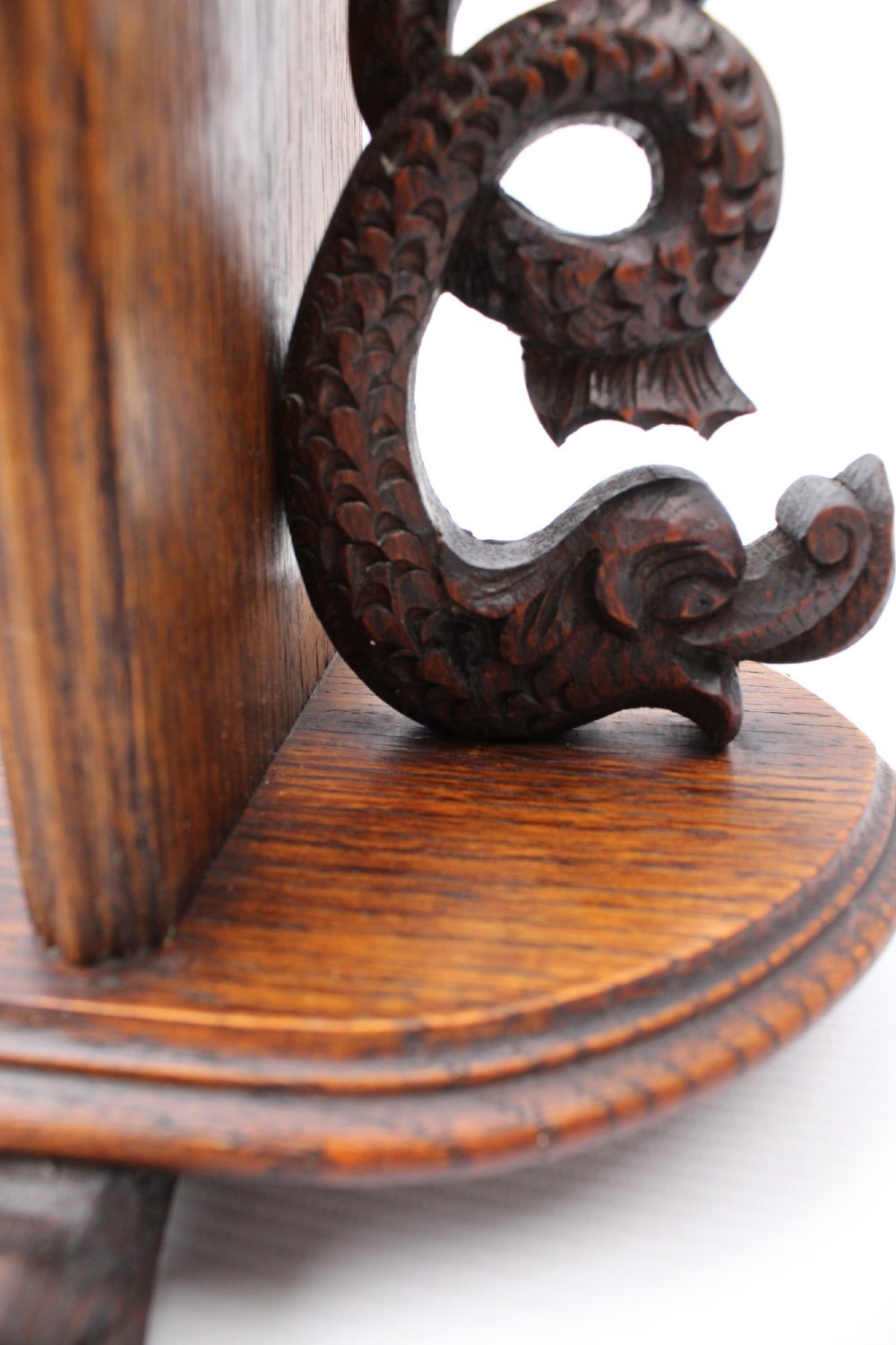 A dark oak desktop book stand featuring pointed arch uprights, carved mythical creature side accents, and scroll feet. View XIII