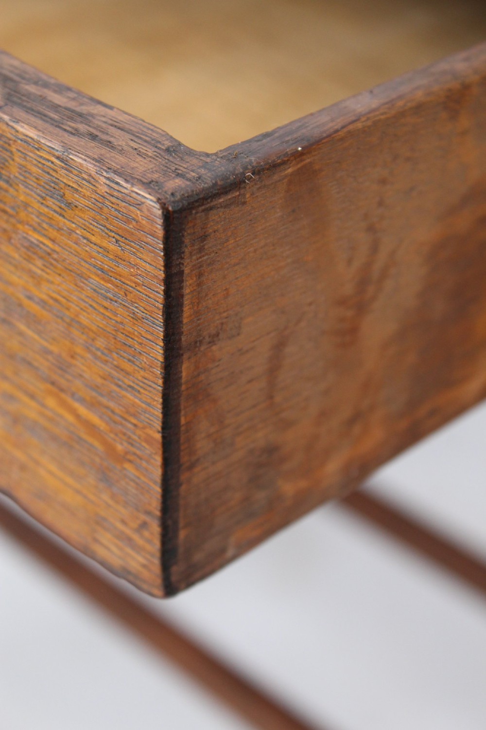 A compact Arts and Crafts oak writing desk featuring a single drawer with a brass drop handle, straight square legs, and lower stretchers. View VIII