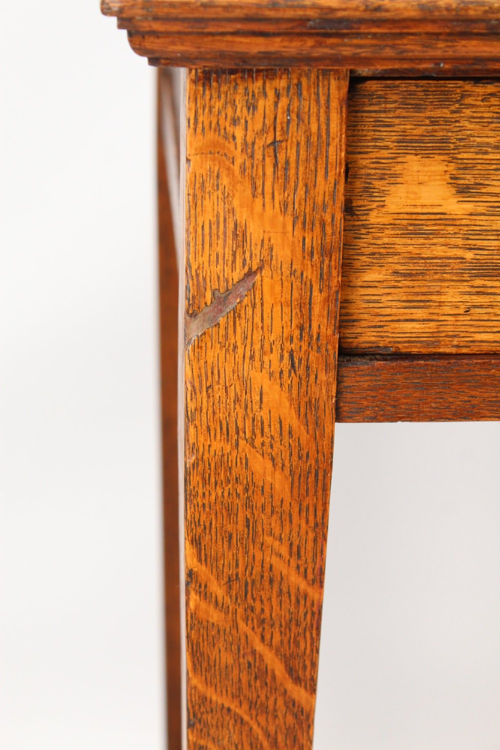 A compact Arts and Crafts oak writing desk featuring a single drawer with a brass drop handle, straight square legs, and lower stretchers. View XI