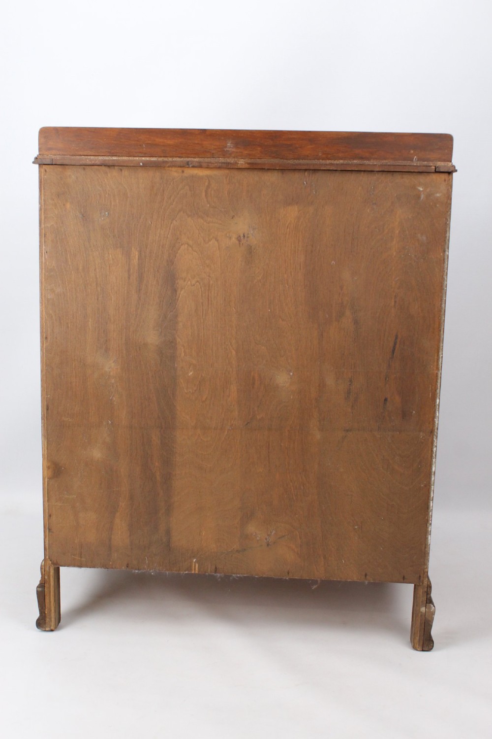 A light oak Art Deco chest of drawers featuring four drawers with textured metal handles, a low gallery back, and bracket feet. View VI
