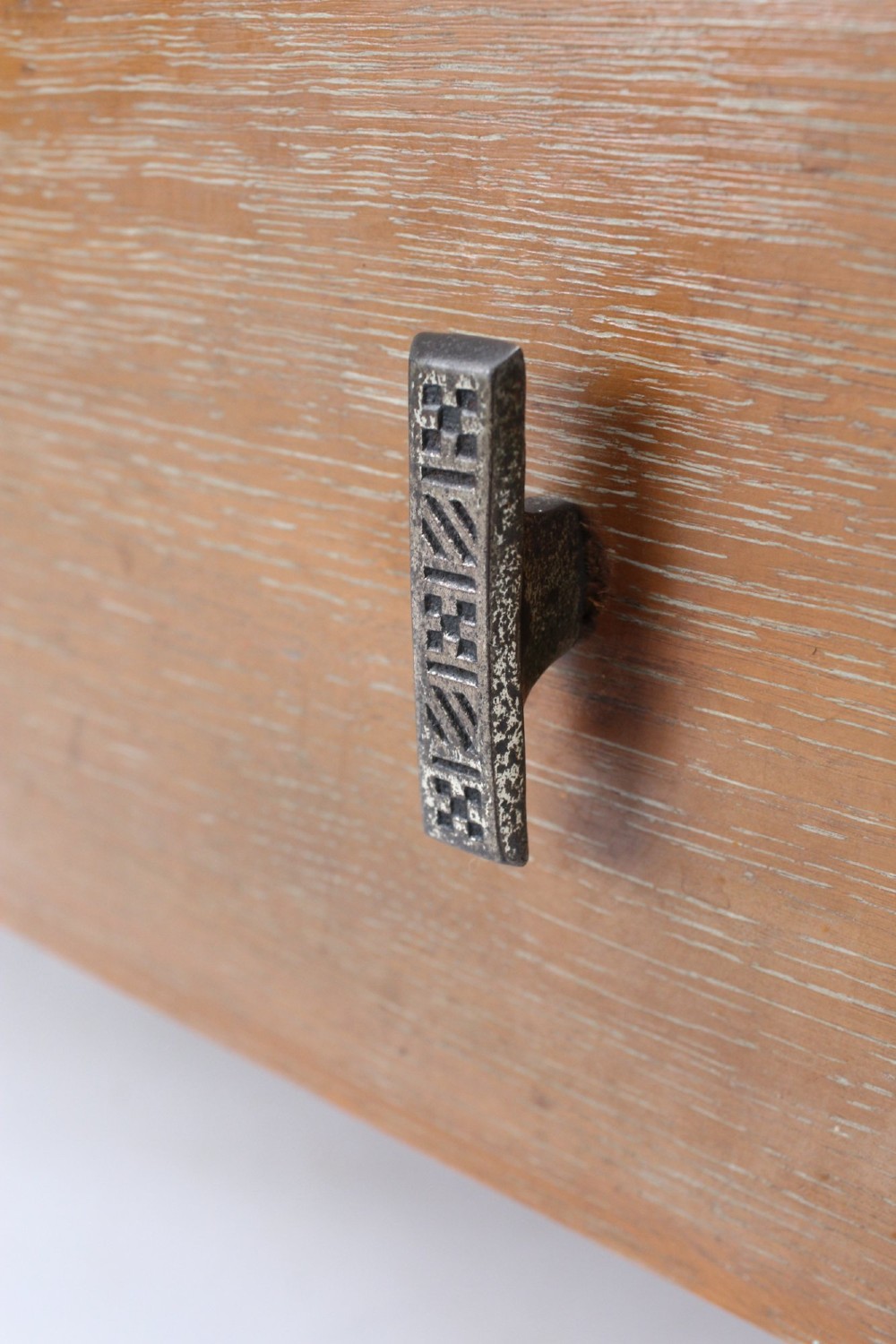 A light oak Art Deco chest of drawers featuring four drawers with textured metal handles, a low gallery back, and bracket feet. View VIII
