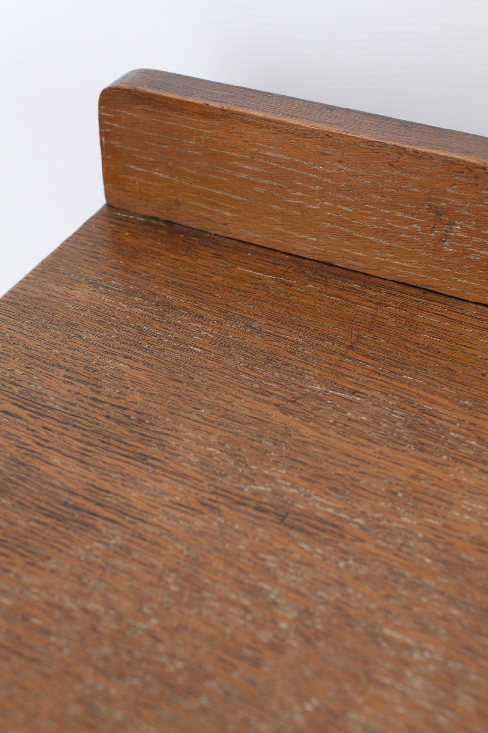 A light oak Art Deco chest of drawers featuring four drawers with textured metal handles, a low gallery back, and bracket feet. View X