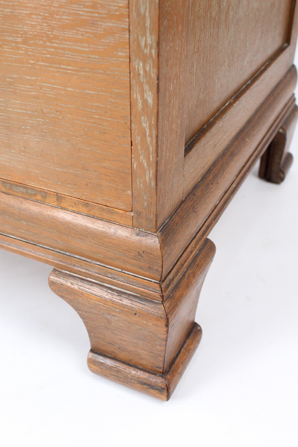 A light oak Art Deco chest of drawers featuring four drawers with textured metal handles, a low gallery back, and bracket feet. View XI