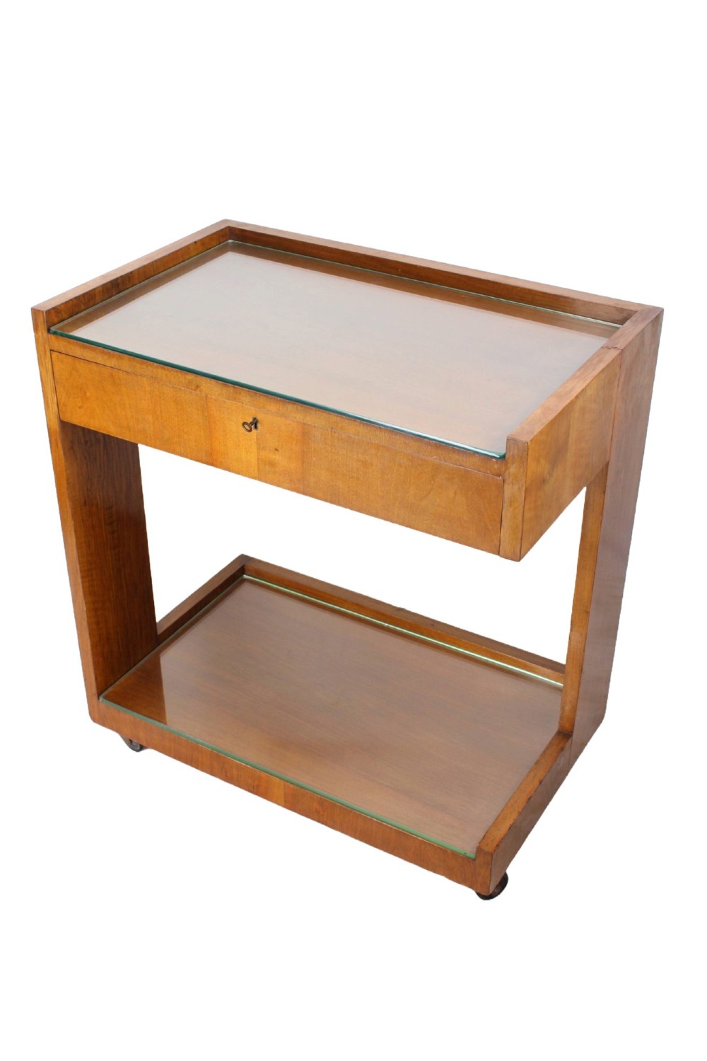 An Art Deco warm brown walnut two-tier trolley featuring inset glass tops, a drawer with a brass keyhole, and concealed castors. View III