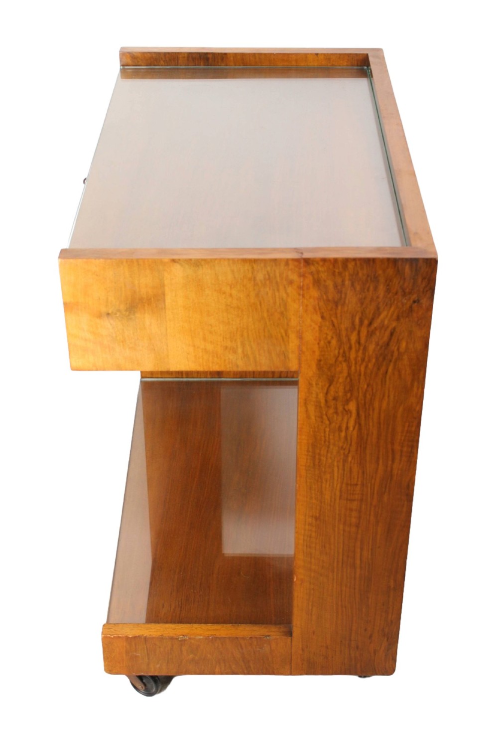 An Art Deco warm brown walnut two-tier trolley featuring inset glass tops, a drawer with a brass keyhole, and concealed castors. View V
