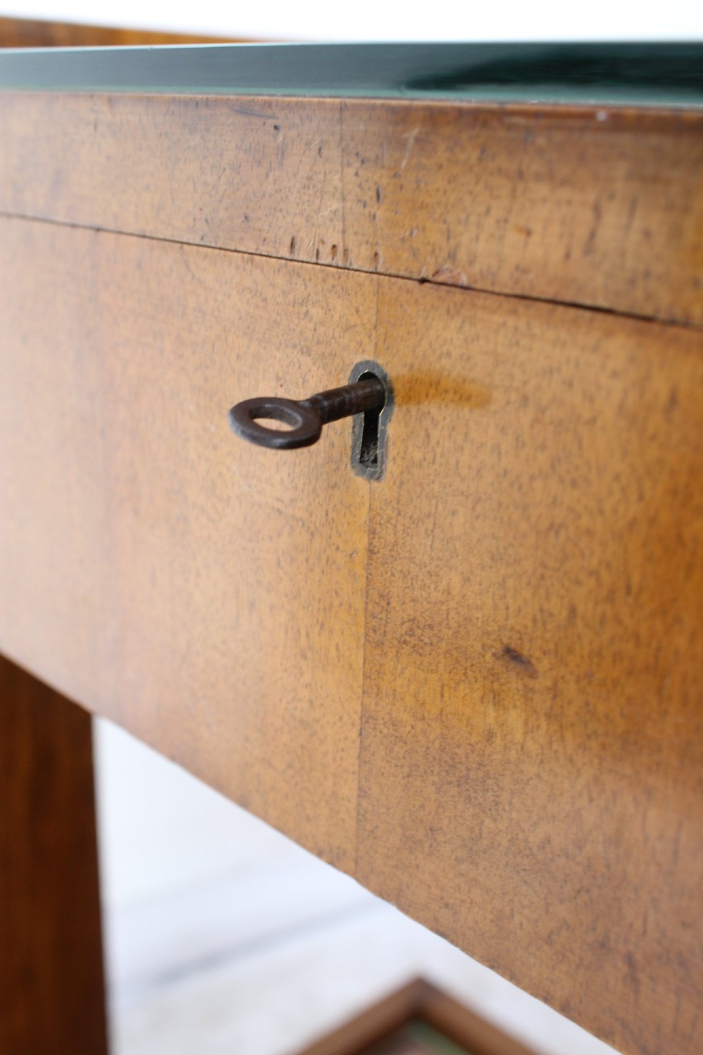 An Art Deco warm brown walnut two-tier trolley featuring inset glass tops, a drawer with a brass keyhole, and concealed castors. View VIII