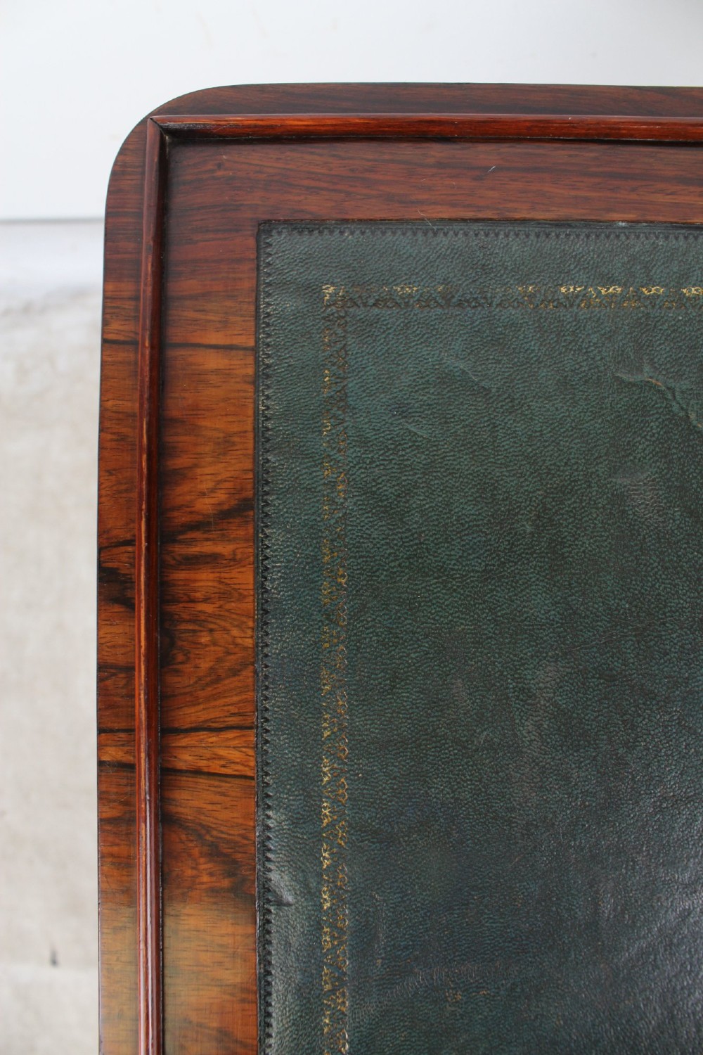 A small Regency rosewood side table featuring an inset green leather top with gold leaf tooling, supported by twin barley twist columns on a trestle base. View XI
