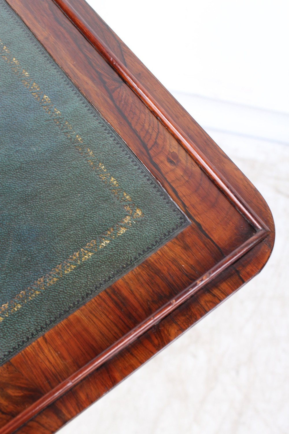 A small Regency rosewood side table featuring an inset green leather top with gold leaf tooling, supported by twin barley twist columns on a trestle base. View XII