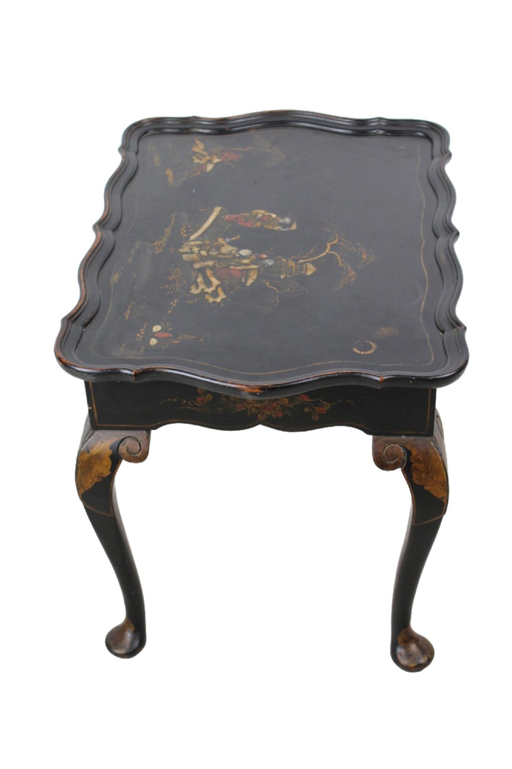 A low black lacquered Edwardian coffee table featuring gilded Chinoiserie figures, a serpentine tray-top edge, and cabriole legs. View V