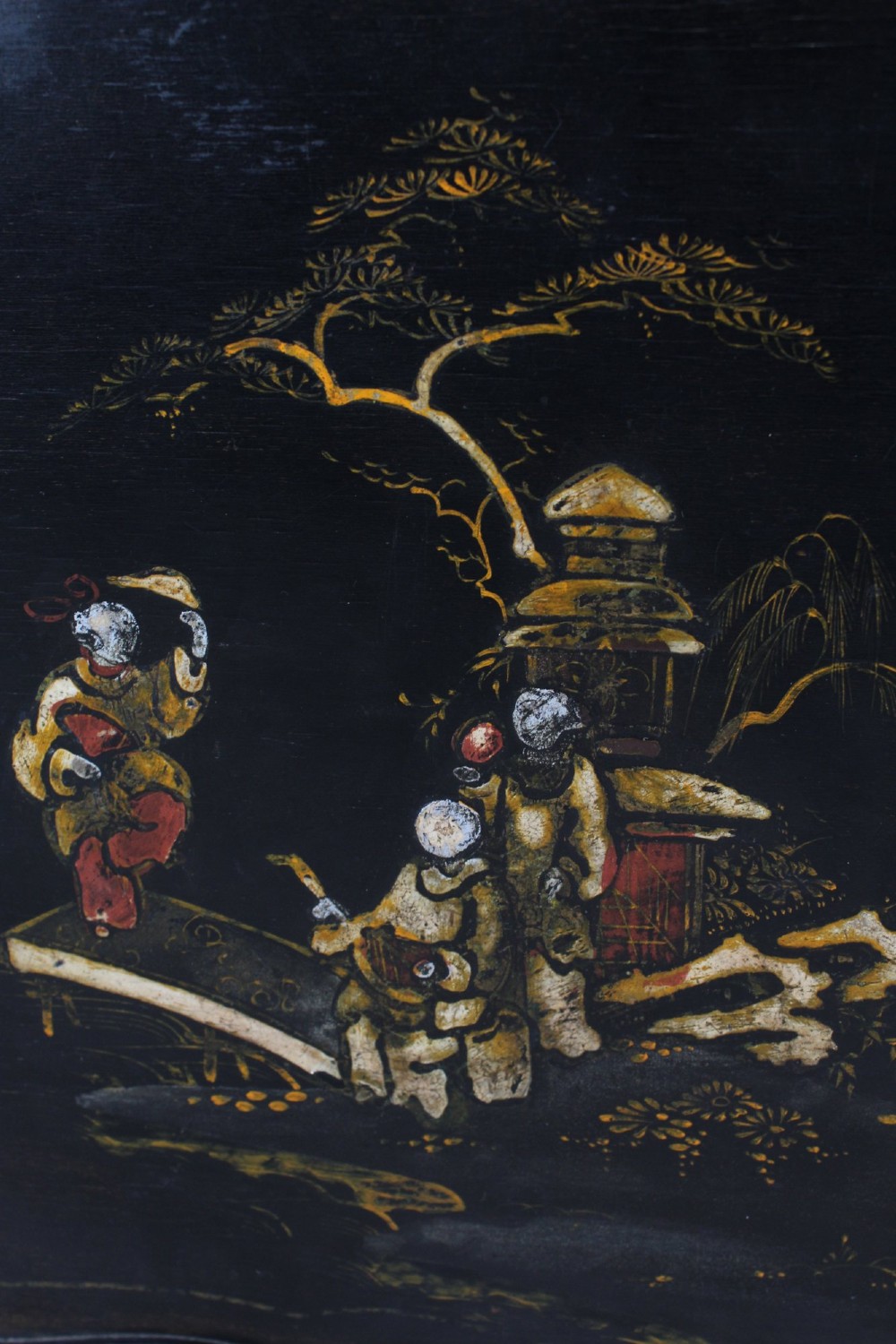 A low black lacquered Edwardian coffee table featuring gilded Chinoiserie figures, a serpentine tray-top edge, and cabriole legs. View VIII