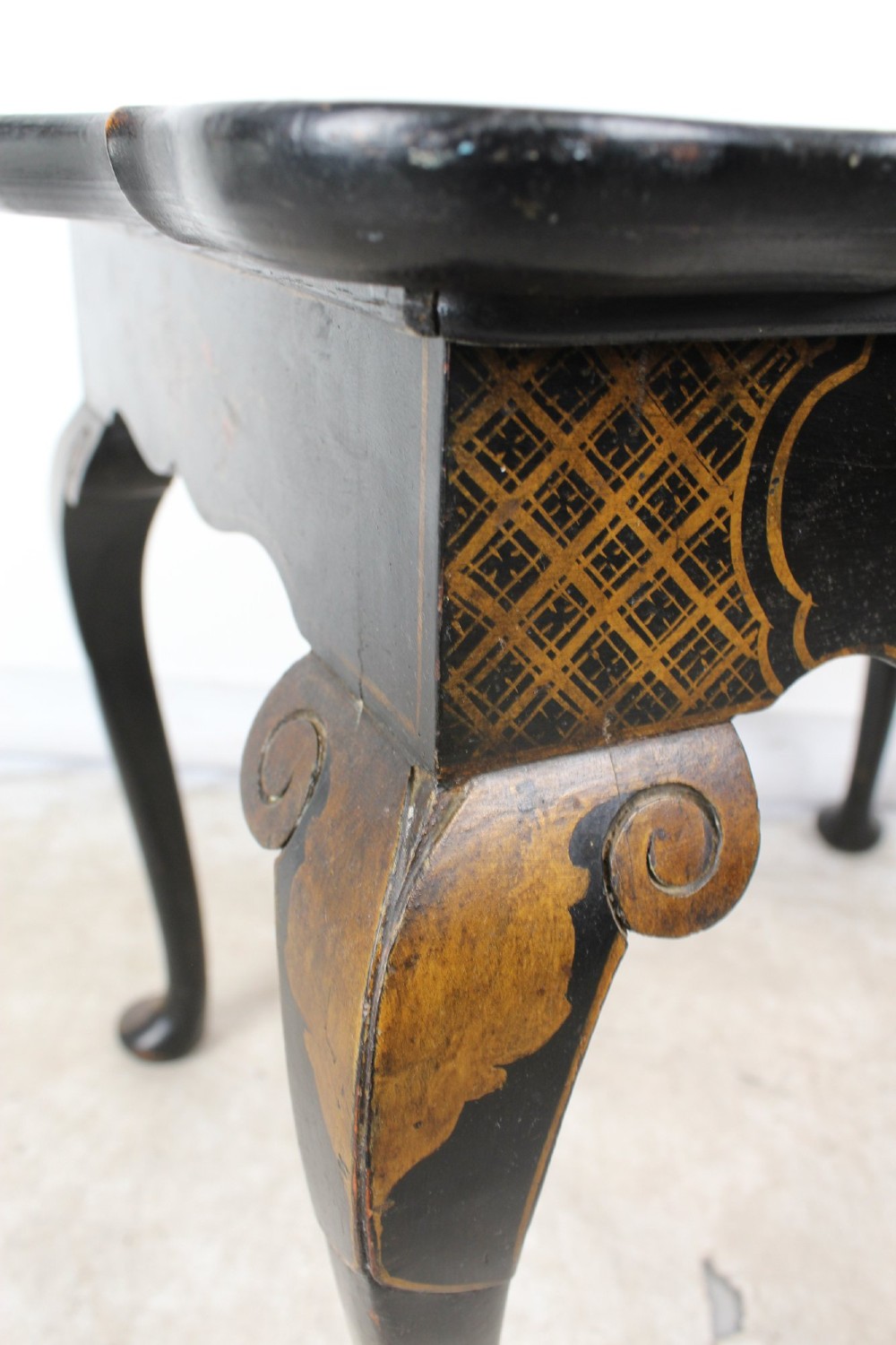 A low black lacquered Edwardian coffee table featuring gilded Chinoiserie figures, a serpentine tray-top edge, and cabriole legs. View XIII