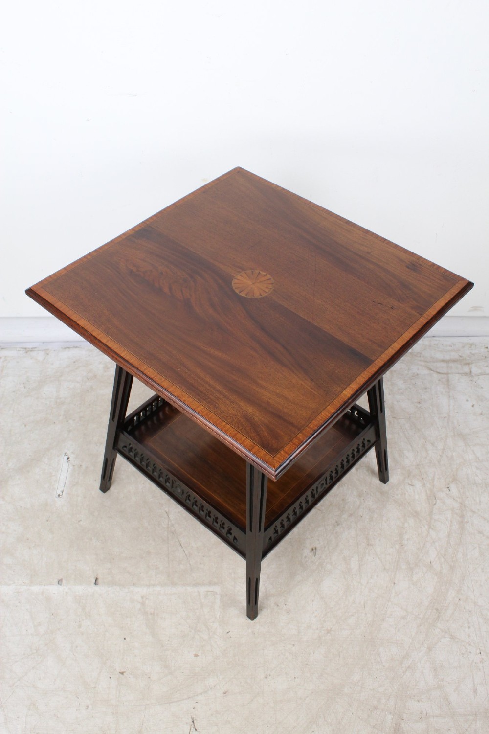 An Edwardian mahogany square side table featuring a central inlaid sunburst medallion, crossbanded border, and a lower undertier shelf with a pierced gallery. View III